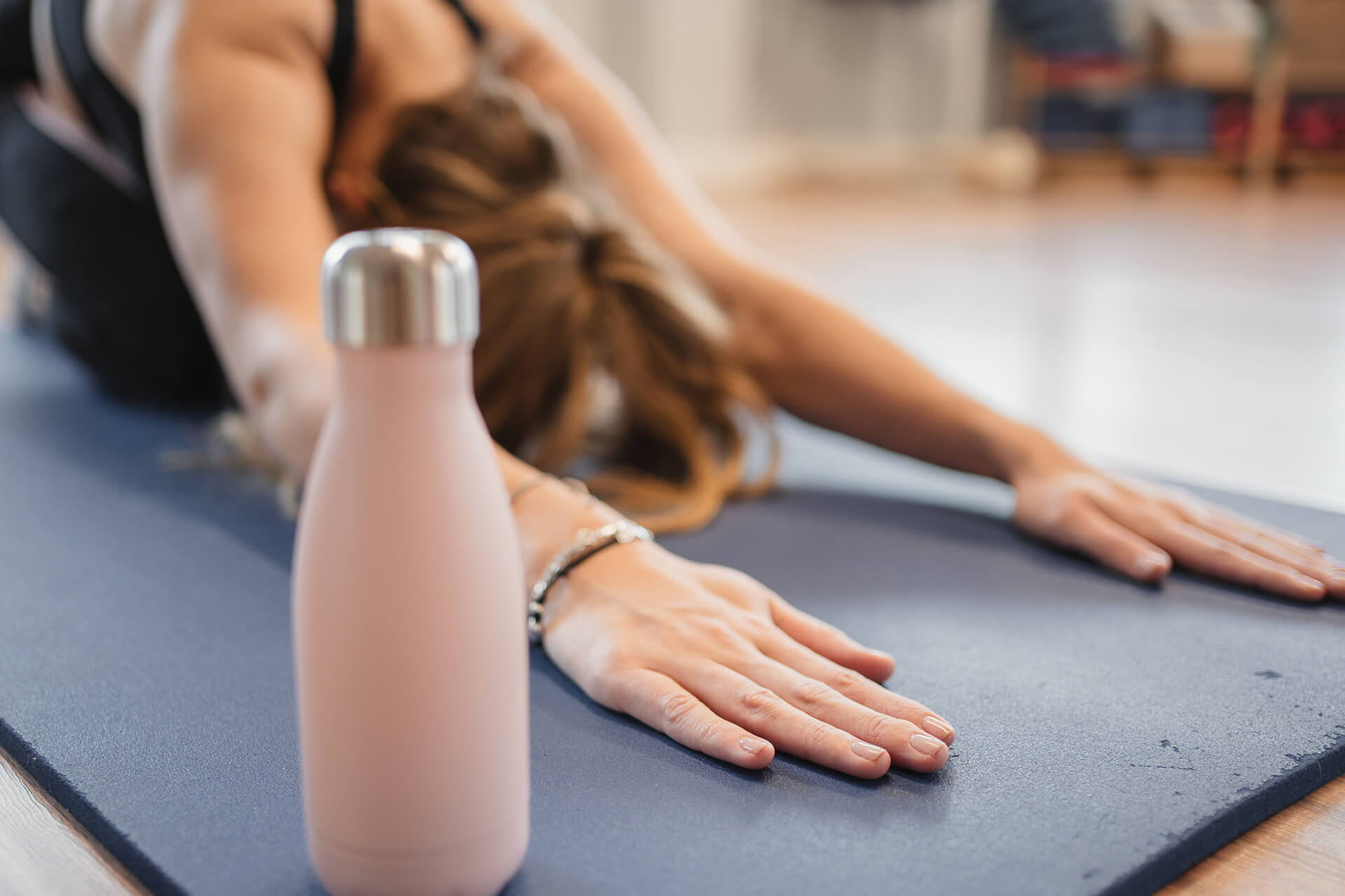 Reusable water bottle with person exercising in background