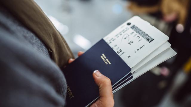 Hand of a person carrying tickets and documents, getting ready for sustainable travel