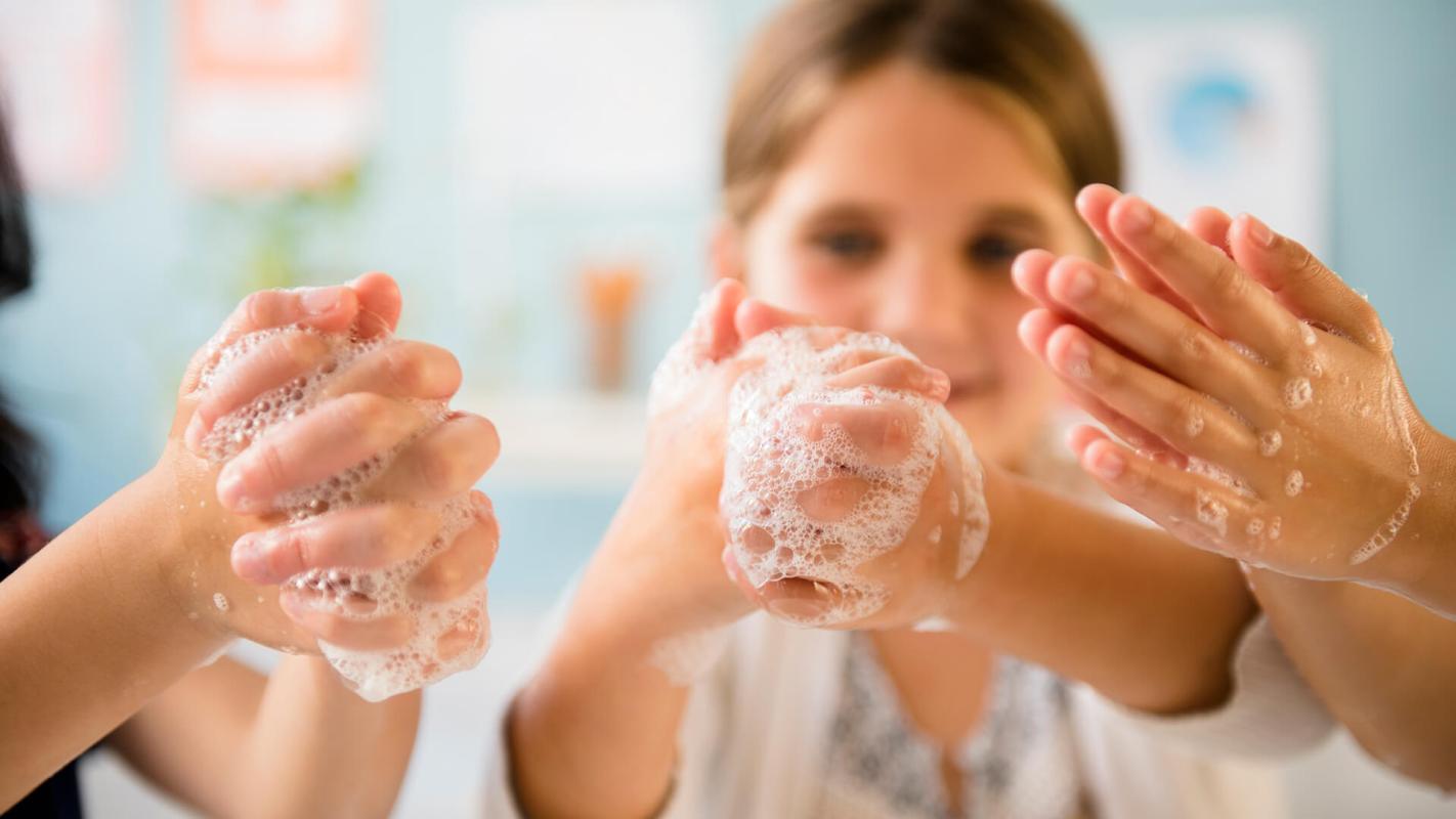 Children washing hands with clean hand soap