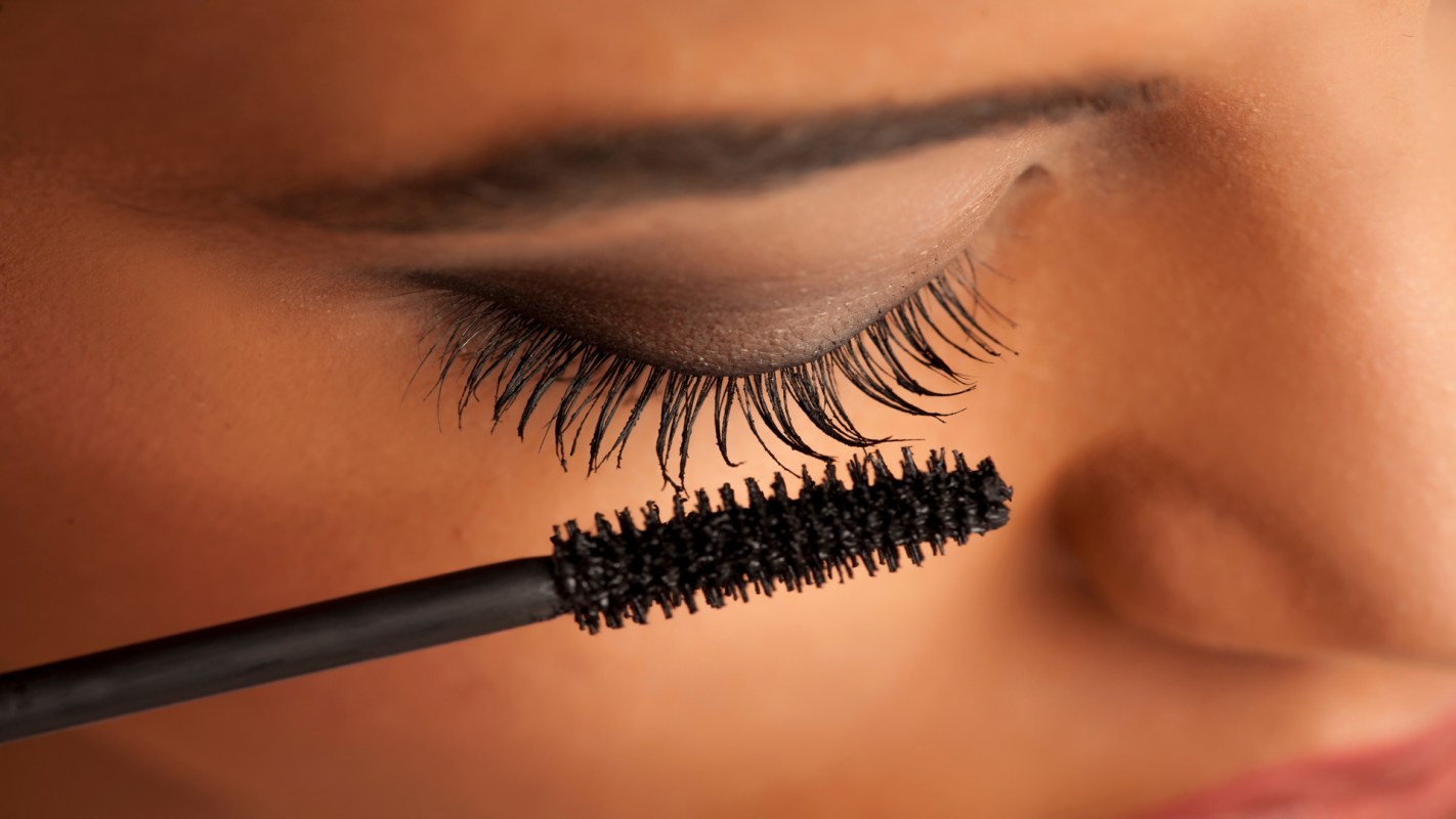 Person applying clean mascara on lashes