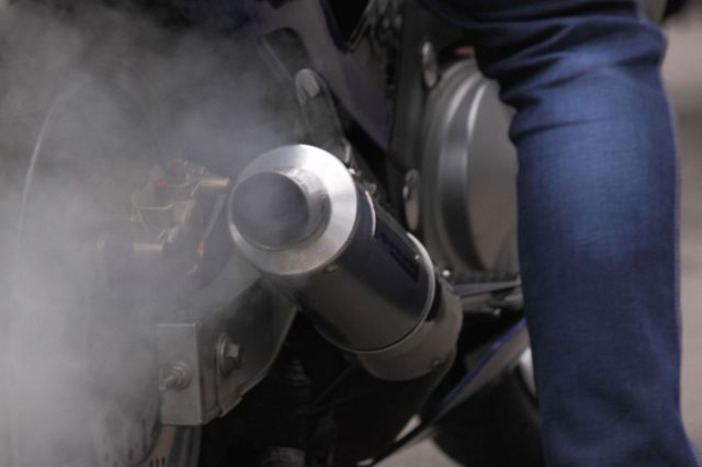 A motorcycle spewing exhaust while idling.