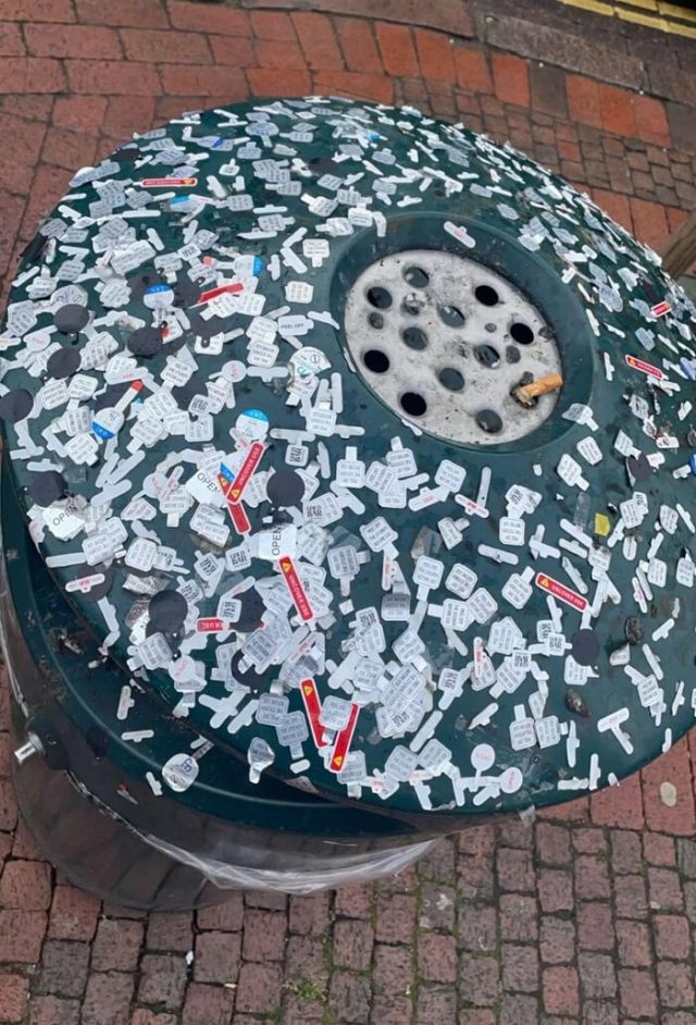 A normal london trashcan caked in vape stickers