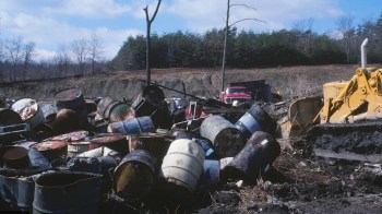 The dumping site has toxic waste containers scattered throughout the forest that were never cleaned up.