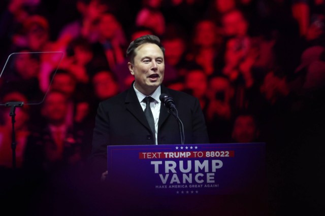 Elon Musk standing behind a podium at a political rally.