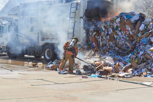 Sanitation workers tried to extinguish a fire that ignited in a garbage truck in the South London neighborhood of Brixton.