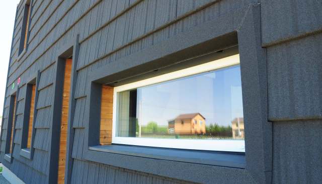 The look is a striking contrast of black elements and mass-produced timber.