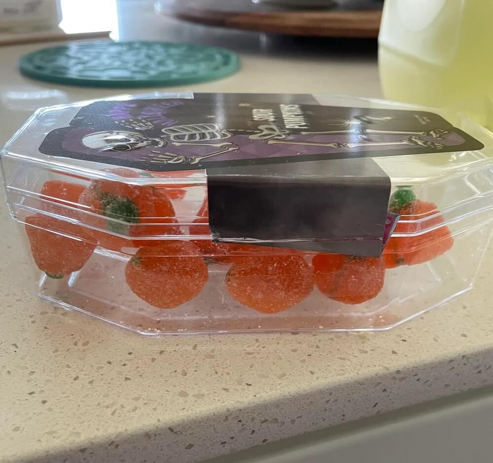 The photos show a coffin-shaped package of Halloween-themed, pumpkin-shaped sour candy.