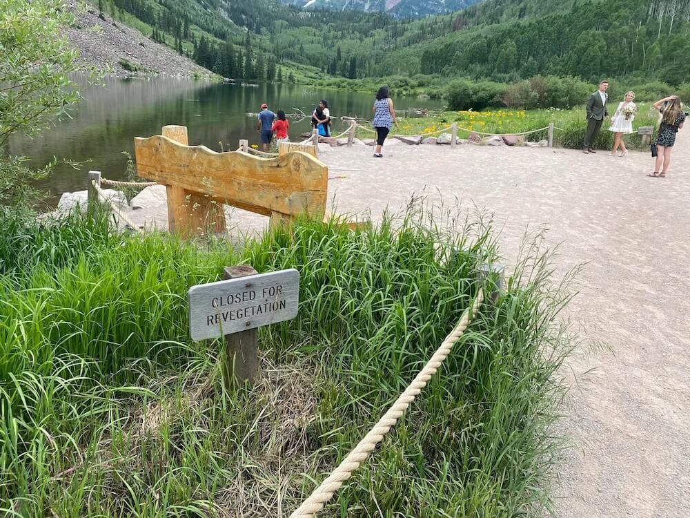 A Redditor shared a photo of a group of people at the Maroon Bells who were disregarding barriers and revegetation signs.