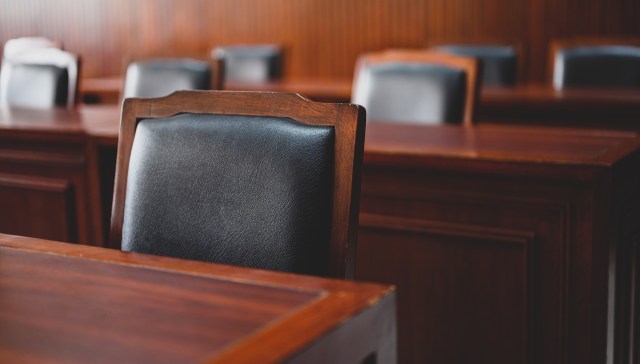 The inside of a courtroom, showing tables and chairs.