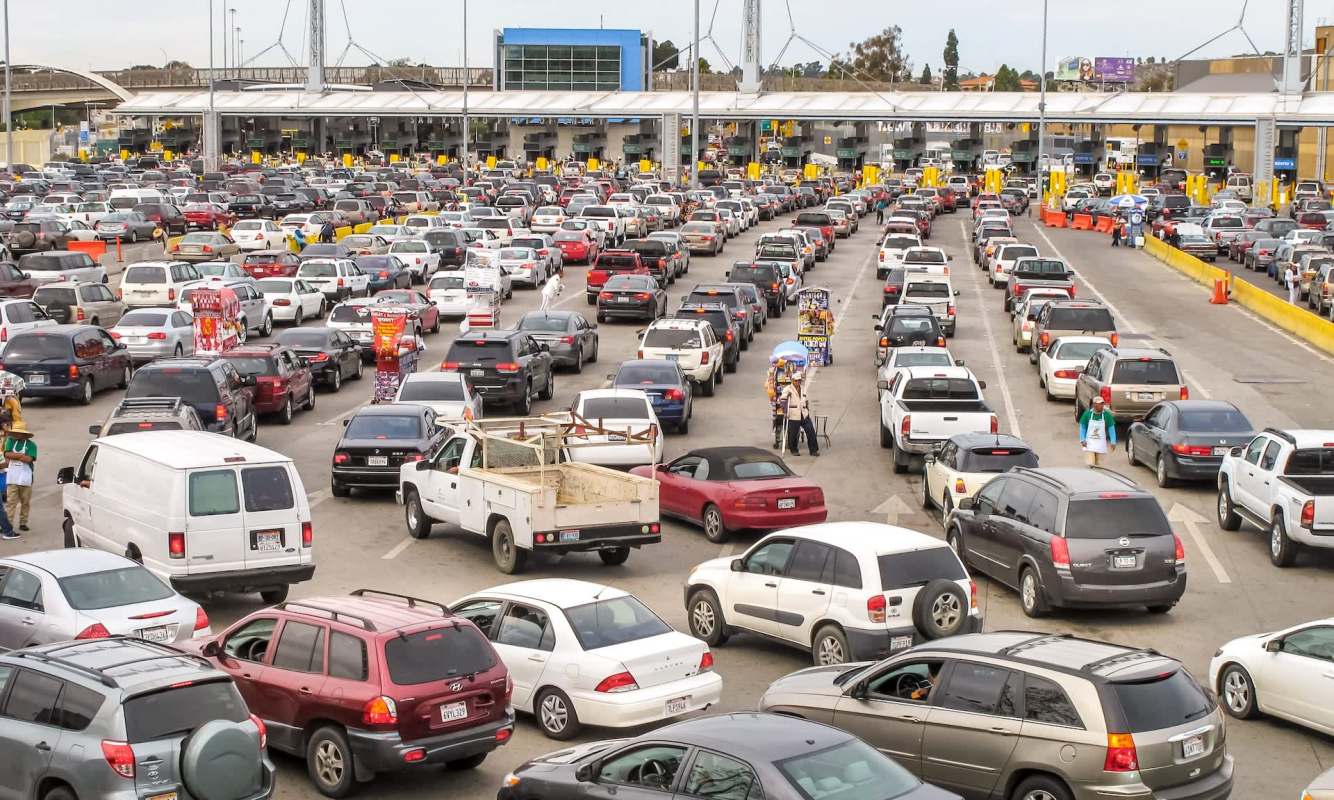 Federal officials arrested a couple allegedly attempting to smuggle three red-lored parrots into the United States by hiding them near a passenger's feet.