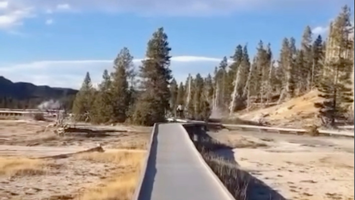 The video shows a person riding a bicycle along one of Yellowstone's elevated boardwalk paths — areas where bikes are explicitly prohibited.