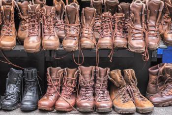 A variety of hiking boots in different shades of brown and black displayed on a shoe rack.