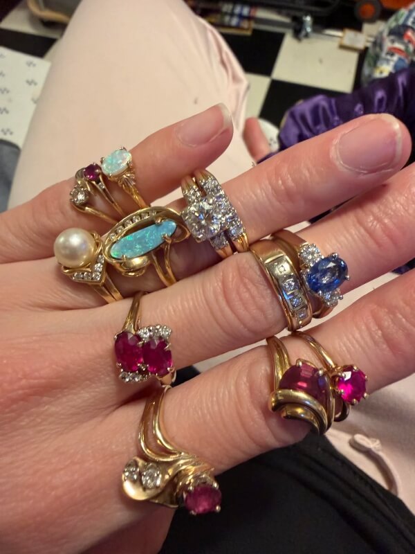A person is modeling multiple rings on their fingers. 