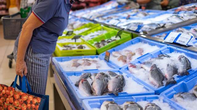 Person looking at fish at supermarket.