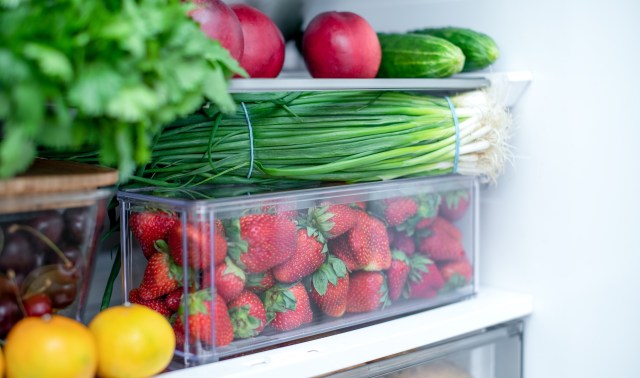 A refrigerator shelf filled with fresh fruits and veggies.