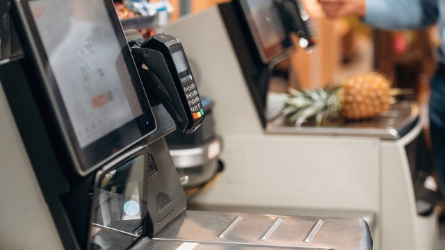 A self-checkout station with a pineapple in the background.