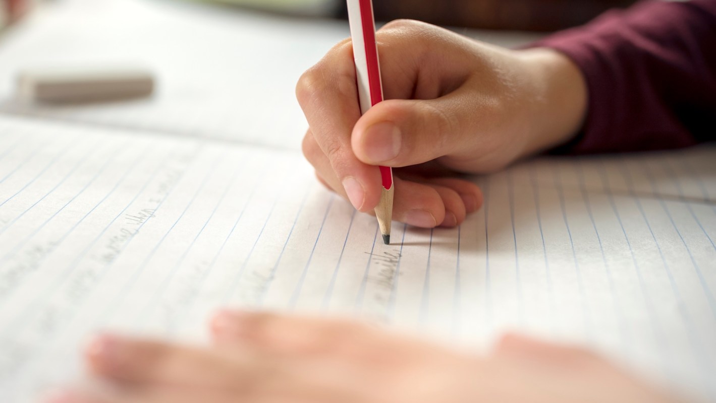 A hand holding a pencil taking notes.