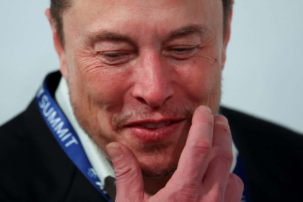 Elon Musk is seen with a hand on his chin.