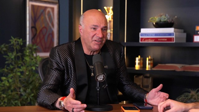 Entrepreneur Kevin O’Leary, in a polka-dot blazer, speaks animatedly into a microphone during a podcast recording.