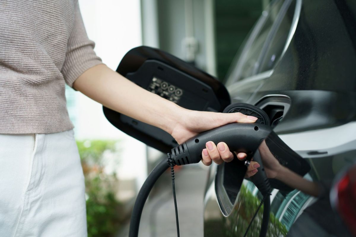 A person using an EV charger at their home.