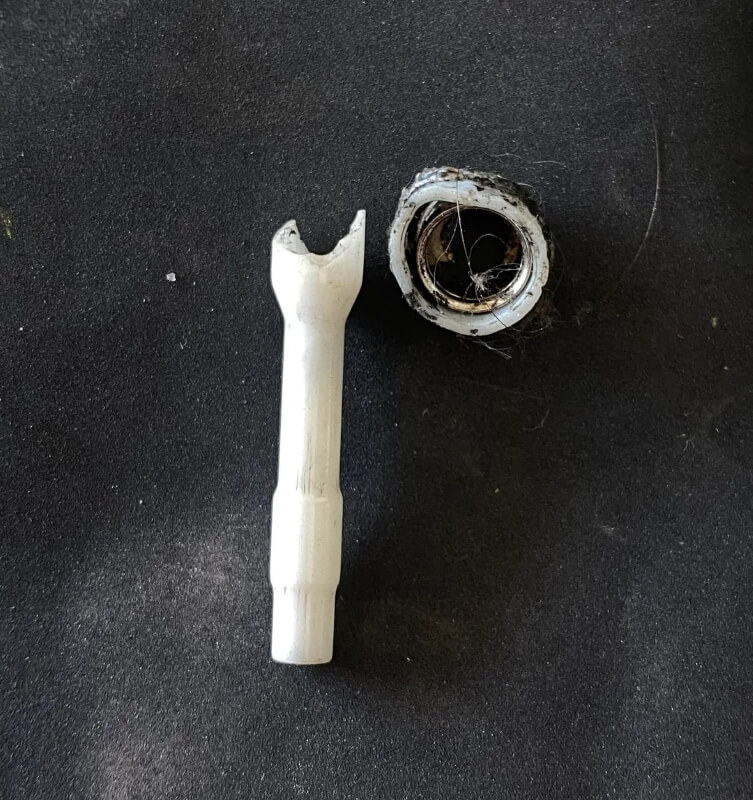 A broken white, glass tubular object.