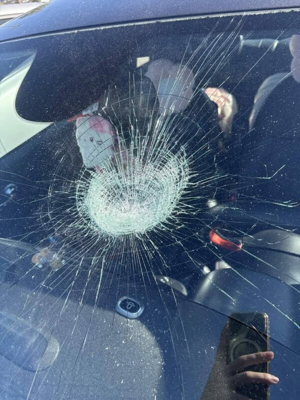 A smashed and cracked front windshield of a car.