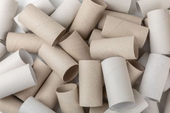 A pile of empty toilet paper rolls in various shades of brown and white.