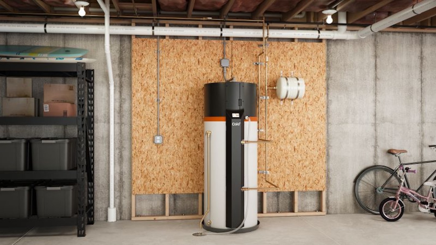 A modern Cala heat pump water heater is installed in a basement, surrounded by storage shelves and a bicycle.