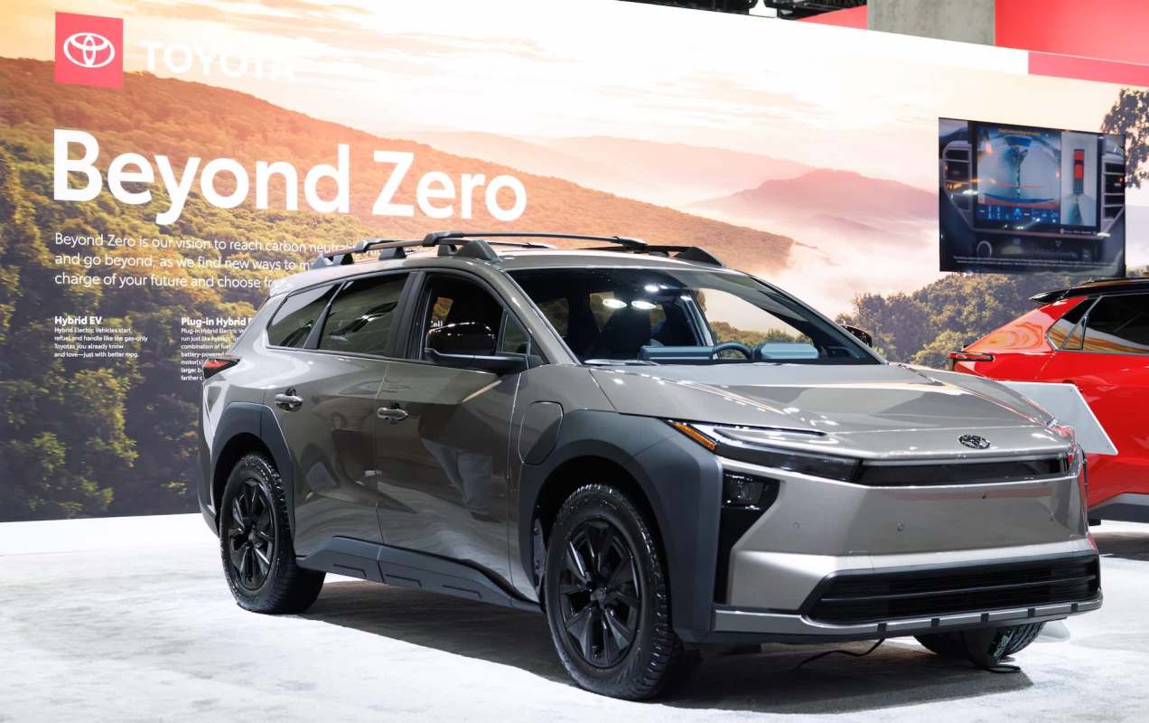 A modern Toyota SUV displayed at an auto show, featuring a 'Beyond Zero' sustainability theme in the background.