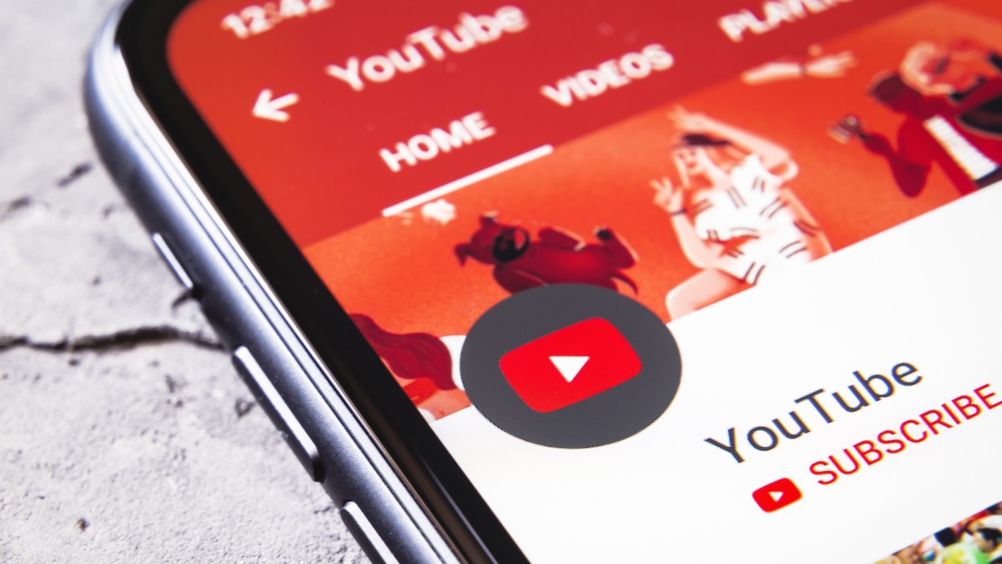 A close-up of a smartphone screen displaying the YouTube app interface with a colorful background.
