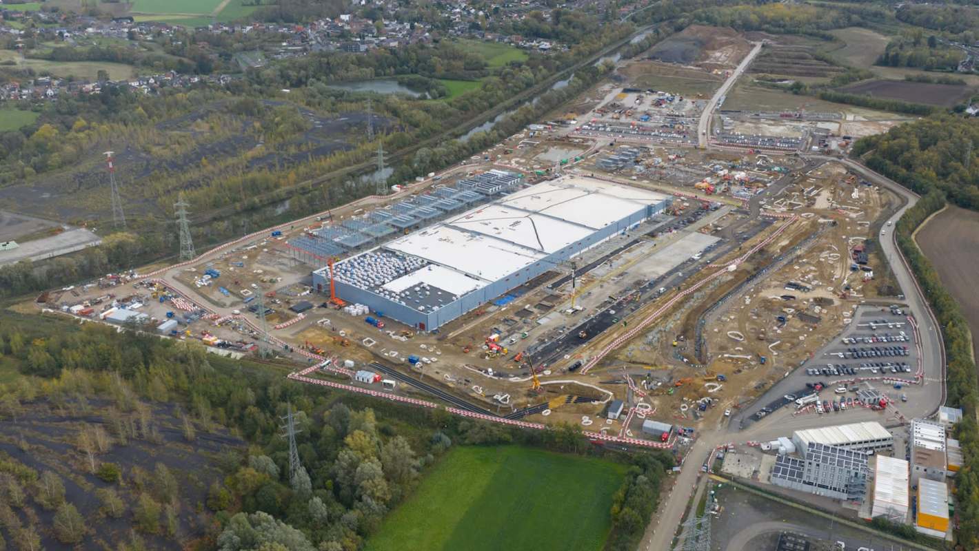 Aerial view of a large construction site with a new data center under development and surrounding land preparation.