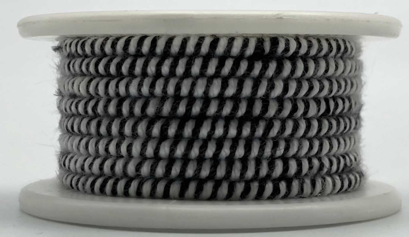 A spool of black and white braided yarn is displayed against a plain background.