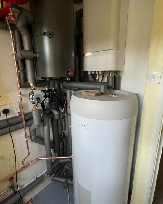 A series of pipes and valves connected to an Aira heat pump.