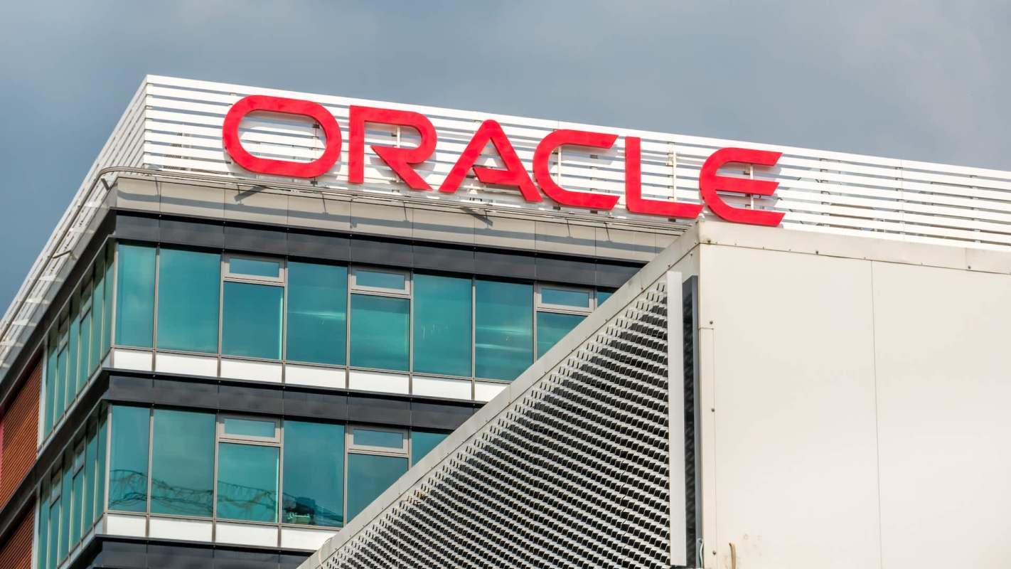 A close-up of a modern building featuring the red "ORACLE" sign on a clear day.