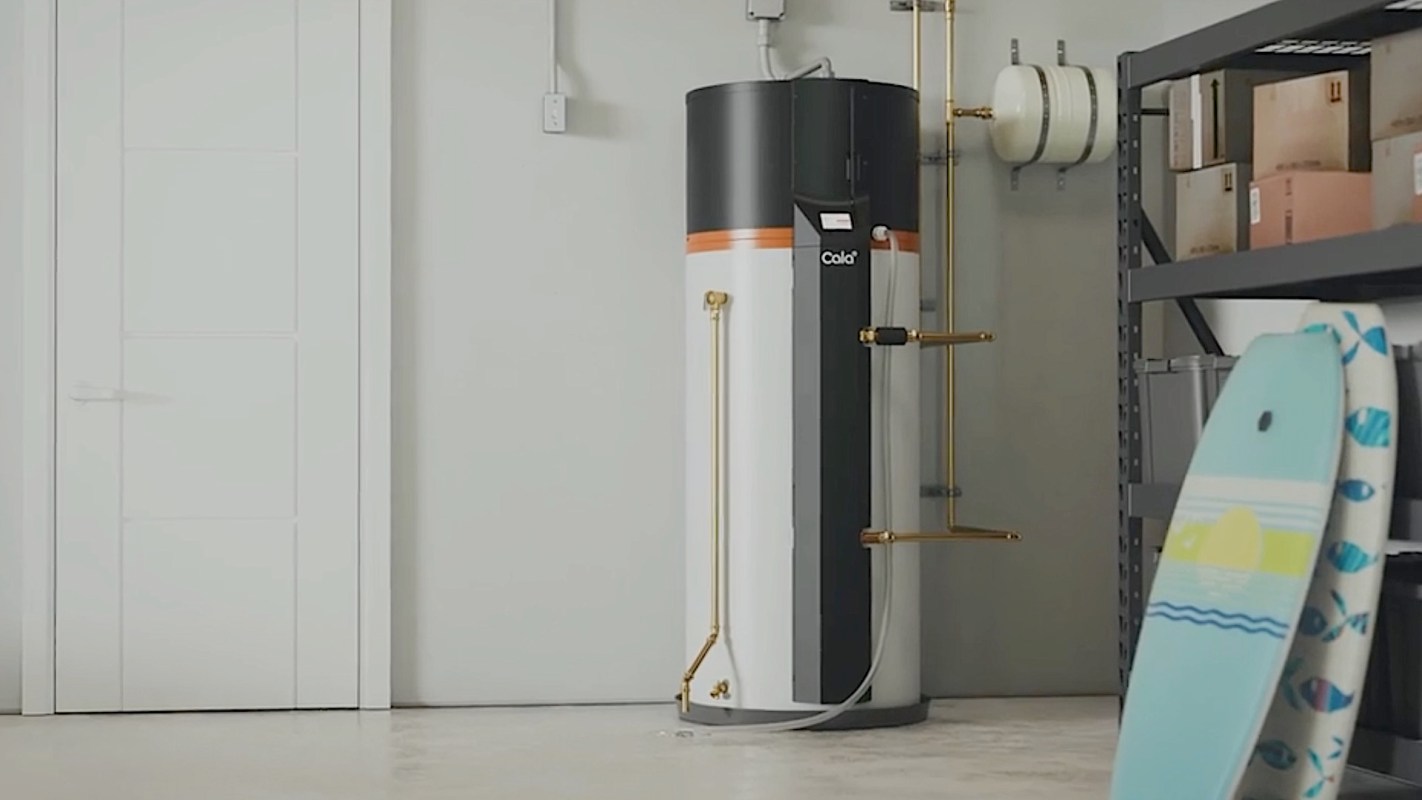 A modern Cala heat pump water heater sits in a garage.