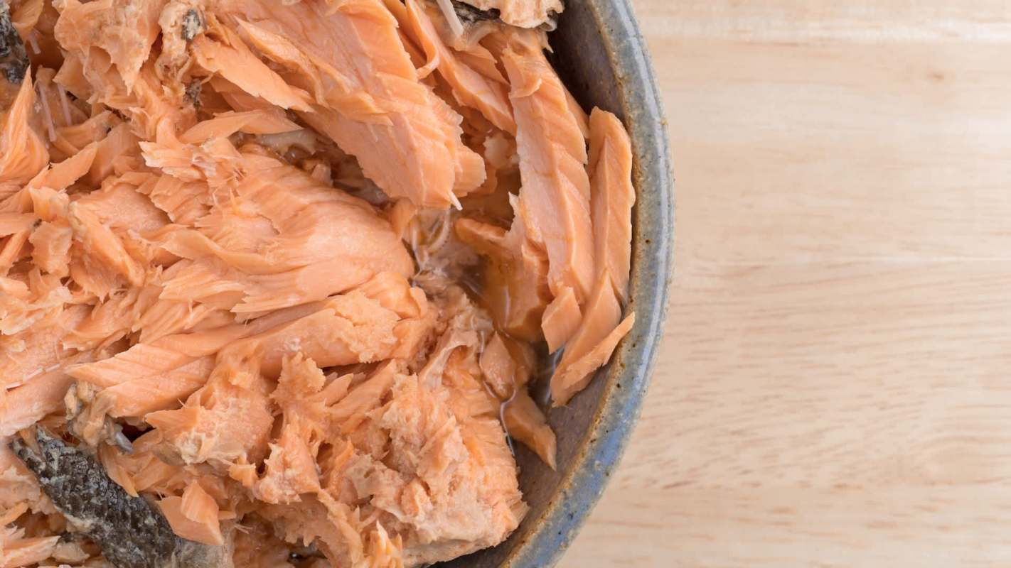 Shredded pink salmon in a ceramic bowl.