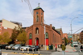 A church in New York City with cars parked in front of it.