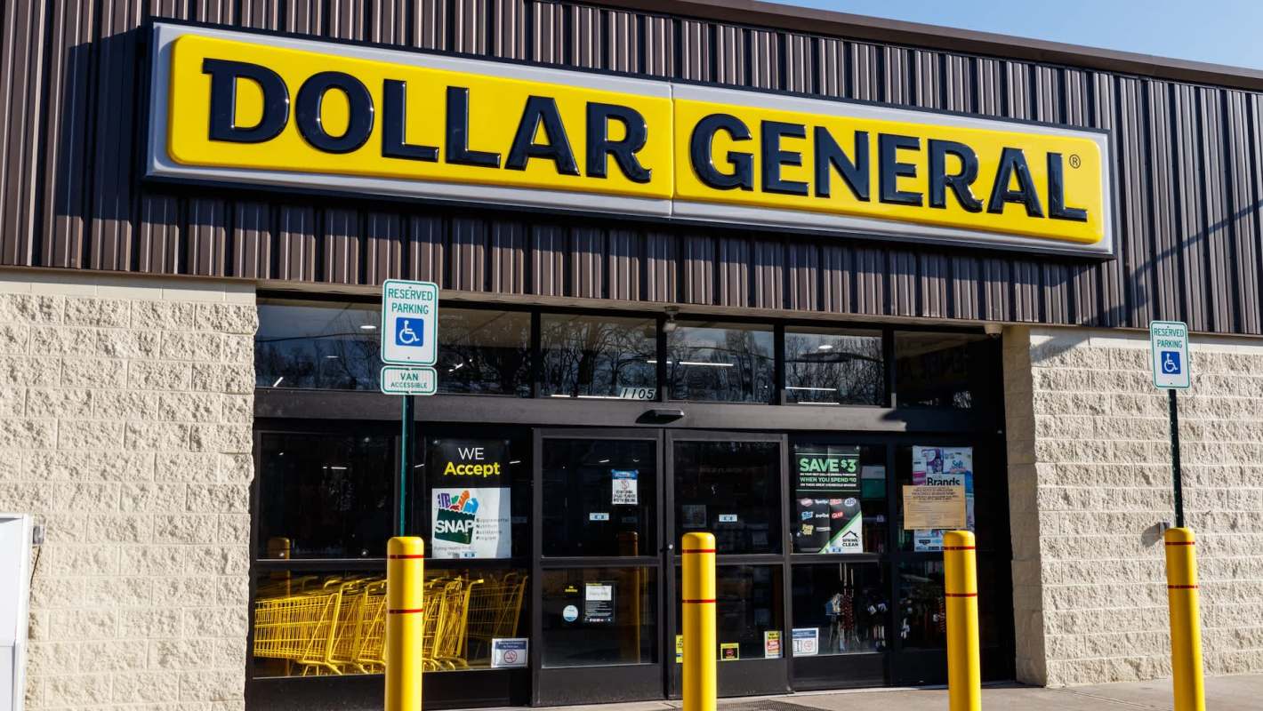 A Dollar General storefront with a large yellow sign and reserved parking signs in front.