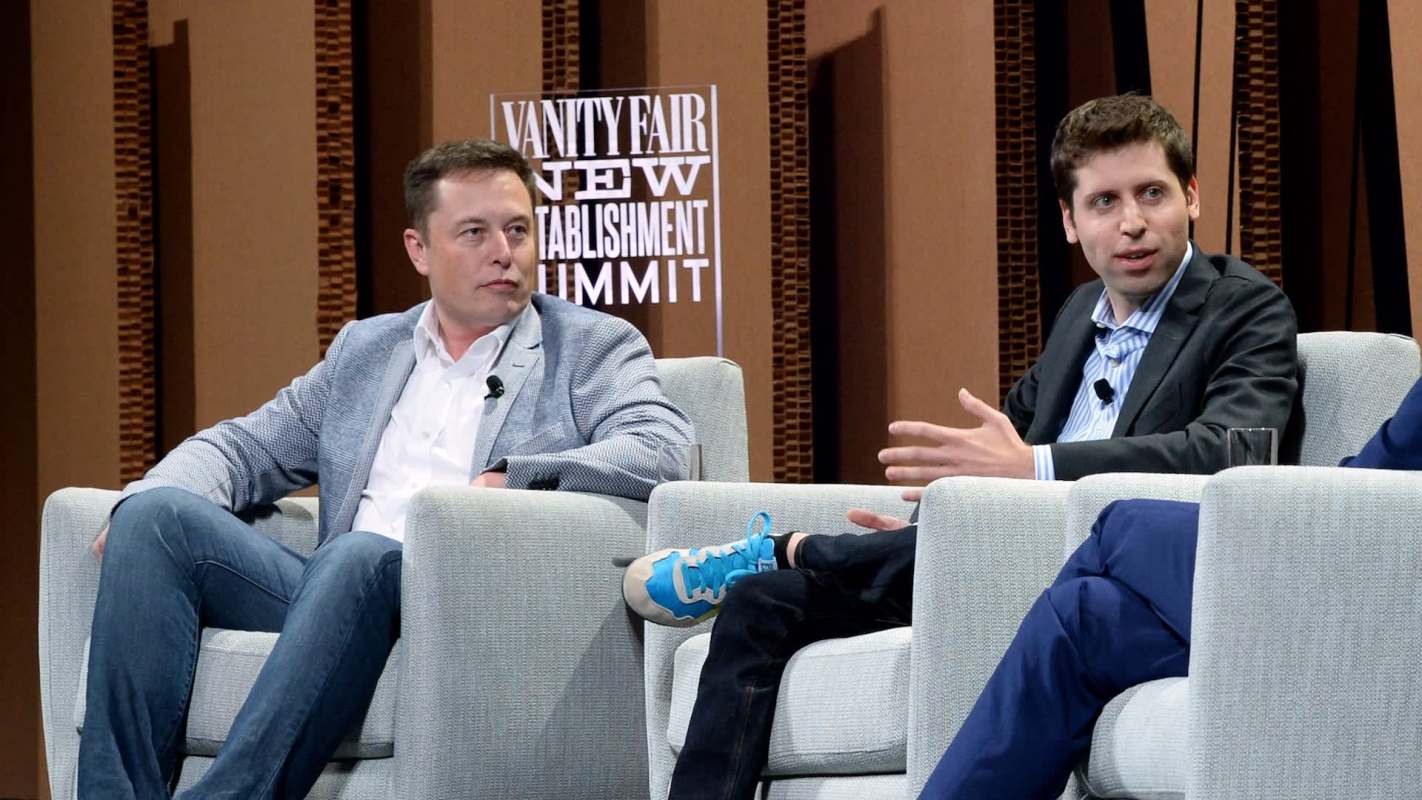 Elon Musk and Sam Altman, both in suits, sit on stage during a discussion at the Vanity Fair New Establishment Summit.