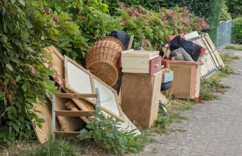 A pile of discarded furniture and items sitting on a curbside.