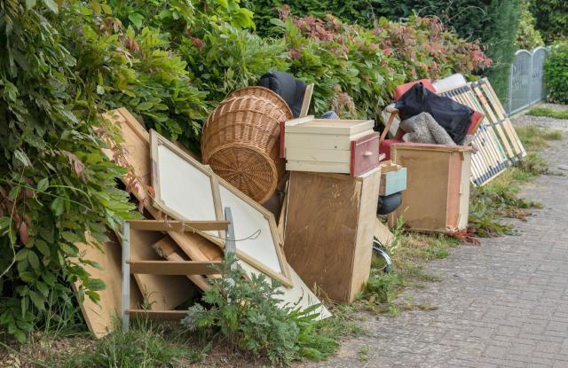 A pile of discarded furniture and items sitting on a curbside.