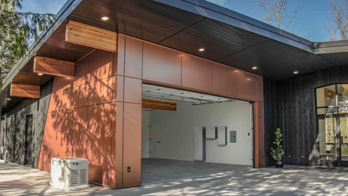 A modern garage with a large opening, featuring metal panels and a minimalist design. A Generac generator sits outside.