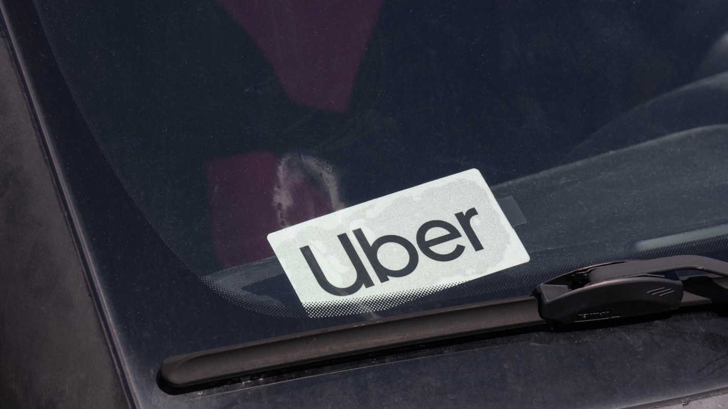 An Uber sticker is displayed on the windshield of a vehicle.
