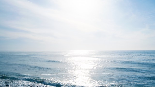 The sun above a calm ocean.