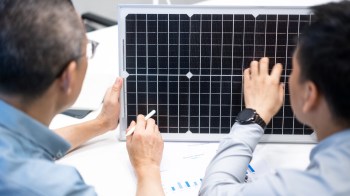 Two people working on solar technology.