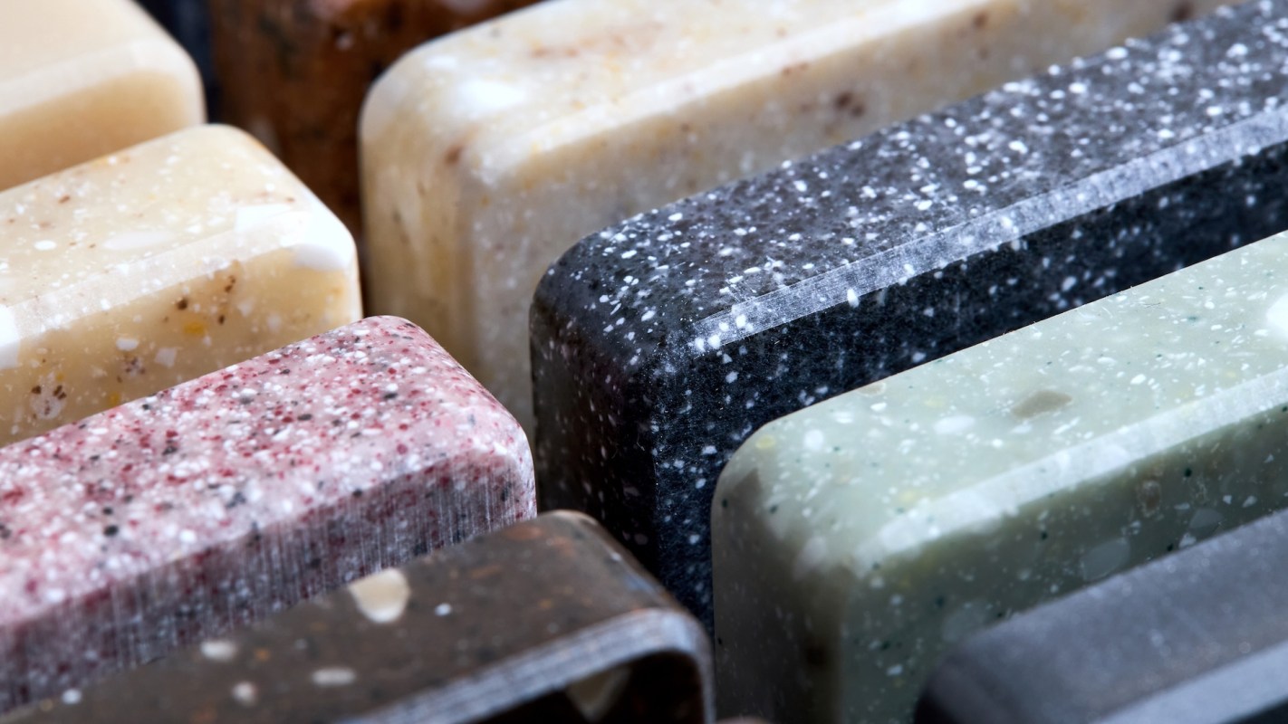A close-up of various artificial porcelain square samples arranged closely together, showcasing different patterns.