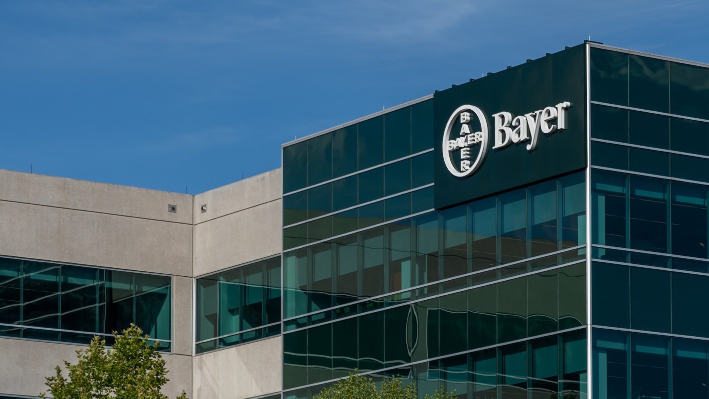 A close-up view of a modern building with a Bayer logo against a clear blue sky.