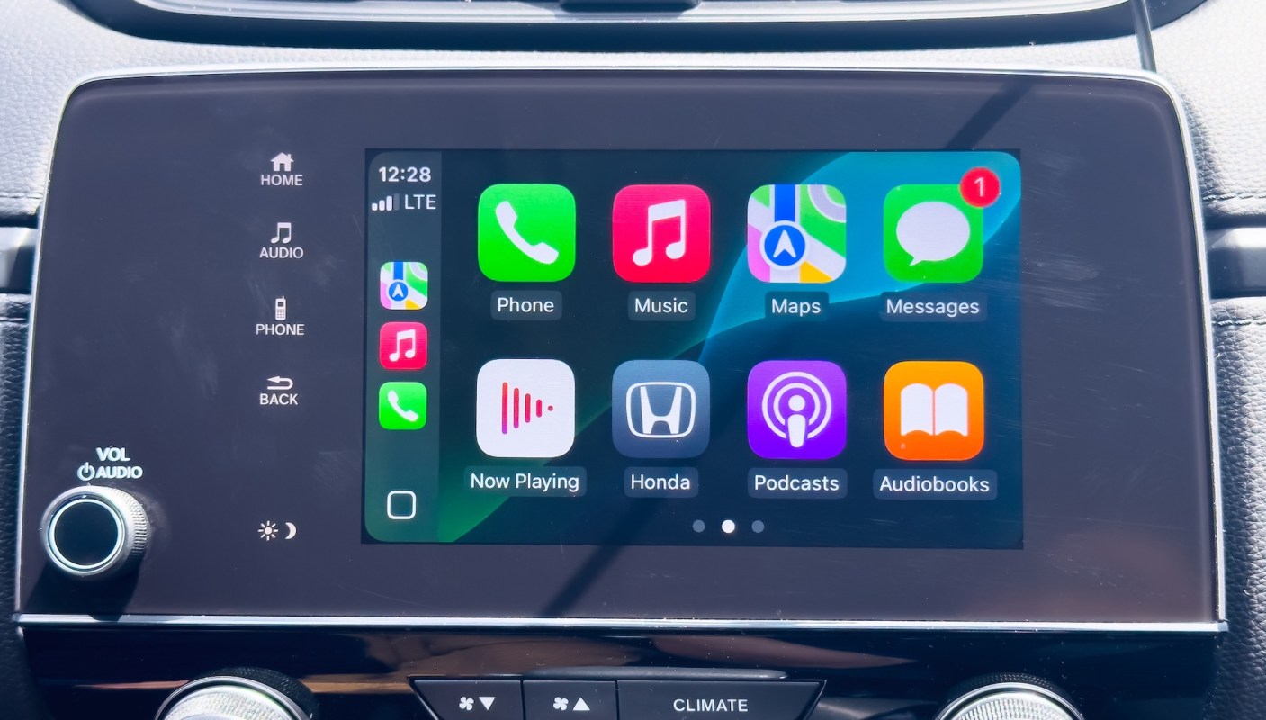 A car infotainment screen displaying various Apple CarPlay apps such as Phone, Music, Maps, and Messages.
