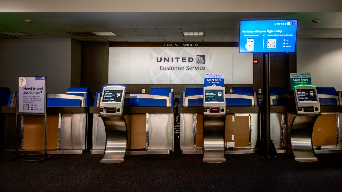 A United Airlines customer service area featuring kiosks and signage for assistance at an airport.
