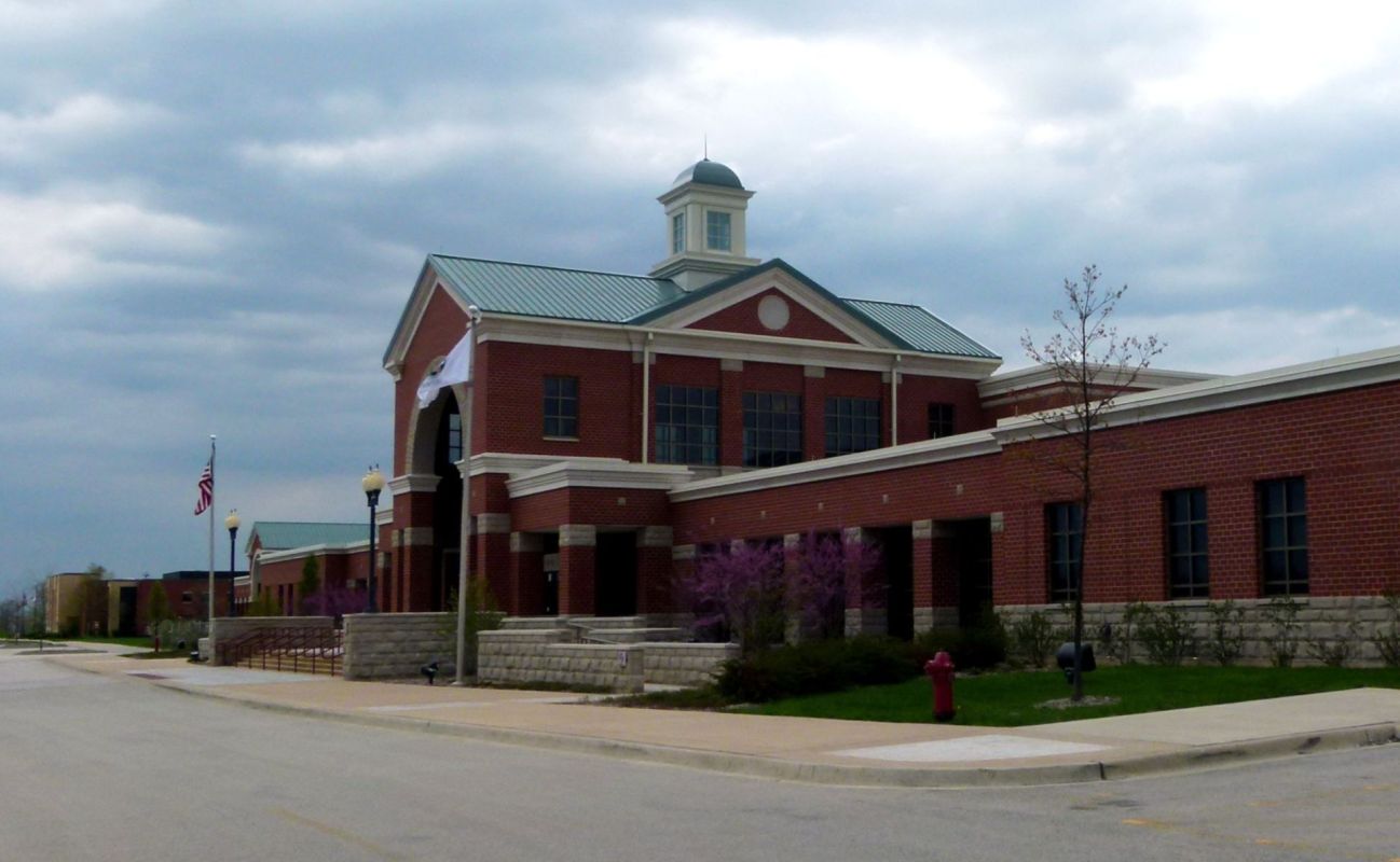 A brick building with a copper roof and a clock tower.